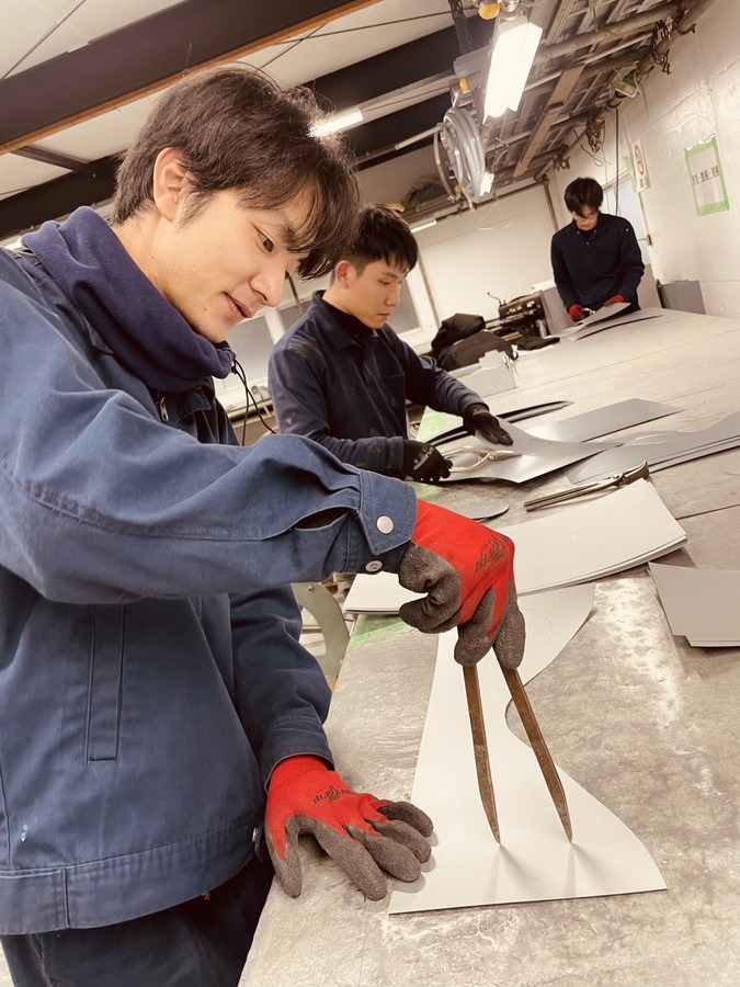 従業員や実習生が板金加工の練習に取り組んでいる様子